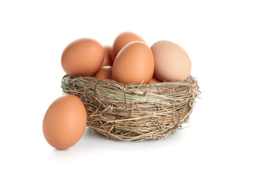 Nest with raw brown chicken eggs on white background