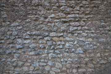 Texture of an ancient stone on a wall covered with moss