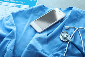 Stethoscope with mobile phone on doctor's uniform. Health concept
