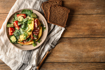 Obraz na płótnie Canvas Tasty omelet with bacon and vegetables on plate