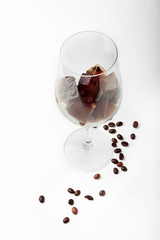 Glass with coffee ice cubes on white background