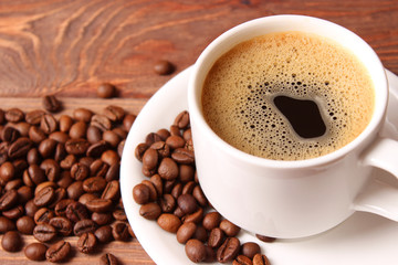 Cup of aromatic coffee and coffee beans on wooden background. Top view. Coffee drink