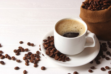 Cup of aromatic coffee and coffee beans on wooden background. Top view. Coffee drink