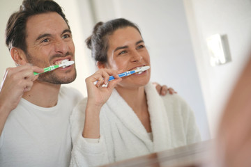  Fun attractive couple brushing teeth together