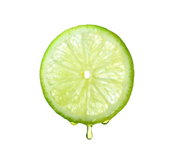 Essential oil dripping from lime slice on white background