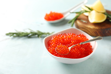 Bowl with delicious red caviar on light table