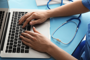 Female doctor using computer at workplace. Health care concept