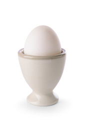 Holder with raw chicken egg on white background