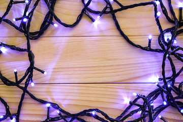 Glowing Christmas lights on wooden table