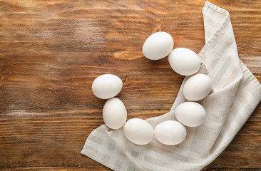 Raw chicken eggs on wooden background