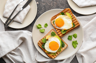 Toasted bread with tasty fried eggs on plate