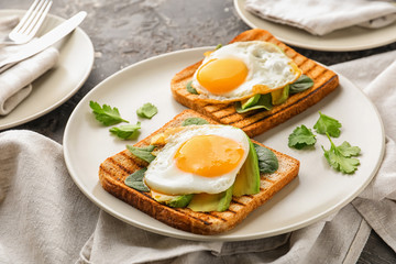 Toasted bread with tasty fried eggs on plate