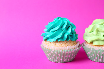 Tasty cupcakes on color background