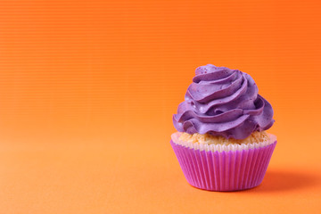 Tasty cupcake on color background