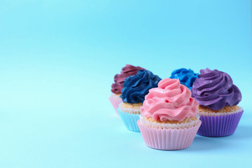 Tasty cupcakes on color background