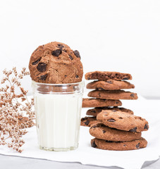  glass of milk and round chocolate chip cookies