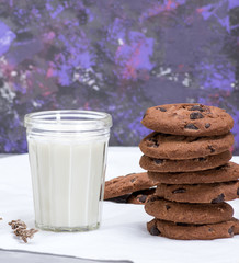 glass of milk and round chocolate chip cookies