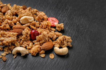 Fototapeta na wymiar Granola with dried fruits and nuts on dark background