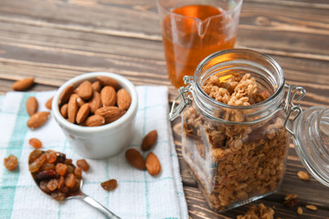 Jar with granola and nuts on wooden table