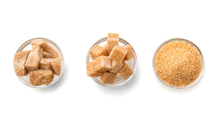 Bowls with different kinds of sugar on white background