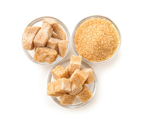 Bowls with different kinds of sugar on white background
