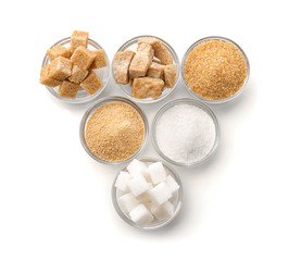Bowls with different kinds of sugar on white background