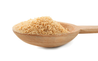 Granulated brown sugar in wooden spoon on white background