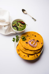 Makki di roti with sarson ka saag, popular punjabi main course recipe in winters made using corn breads mustard leaves curry. served over moody background. selective focus