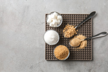 Different kinds of sugar on grey table
