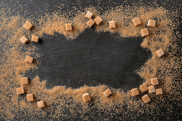 Frame made of brown sugar on dark table