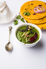 Makki di roti with sarson ka saag, popular punjabi main course recipe in winters made using corn breads mustard leaves curry. served over moody background. selective focus