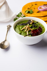 Makki di roti with sarson ka saag, popular punjabi main course recipe in winters made using corn breads mustard leaves curry. served over moody background. selective focus