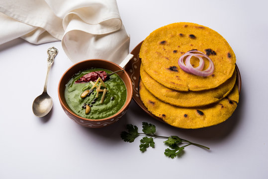 Makki di roti with sarson ka saag, popular punjabi main course recipe in winters made using corn breads mustard leaves curry. served over moody background. selective focus