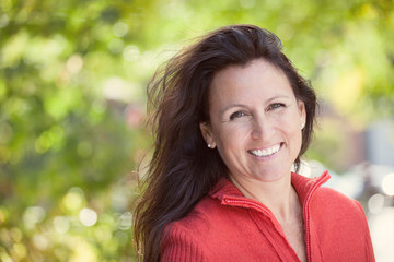 Portrait Of A Mature Woman Smiling At the Camera In a Forest