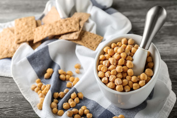 Mortar full of chickpeas on wooden table
