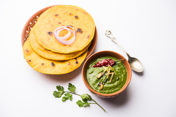Makki di roti with sarson ka saag, popular punjabi main course recipe in winters made using corn breads mustard leaves curry. served over moody background. selective focus