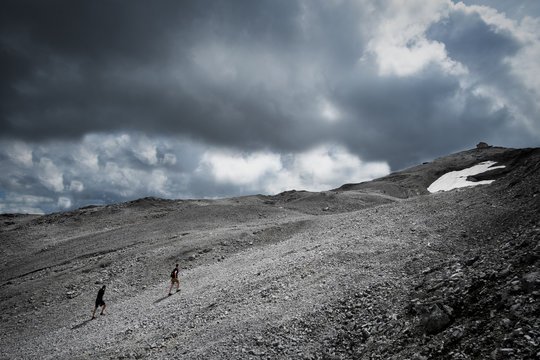 Two backpacker friends are hiking up at the Stelvio to the summit