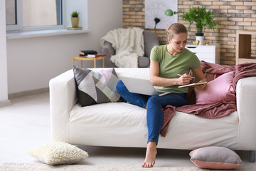 Obraz premium Female student with laptop studying at home