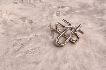 Metal brain teaser on grey textured background
