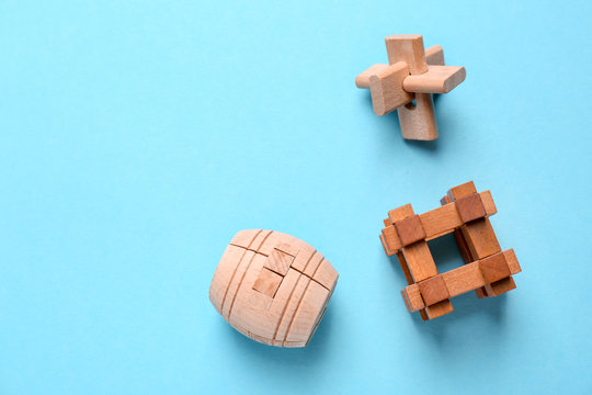 Wooden puzzles on color background