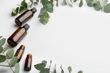 Bottles of eucalyptus essential oil on white background