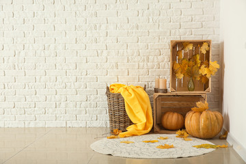Beautiful autumn composition with pumpkins and leaves near white brick wall