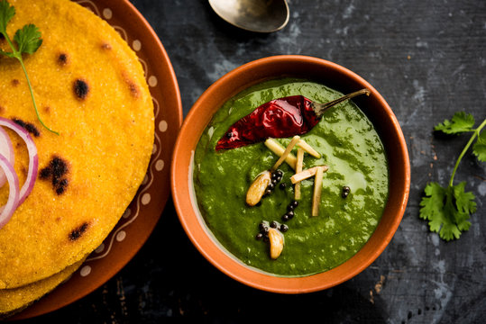 Makki di roti with sarson ka saag, popular punjabi main course recipe in winters made using corn breads mustard leaves curry. served over moody background. selective focus
