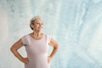 Fototapeta na wymiar Portrait of senior woman on color background