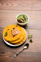 Makki di roti with sarson ka saag, popular punjabi main course recipe in winters made using corn breads mustard leaves curry. served over moody background. selective focus
