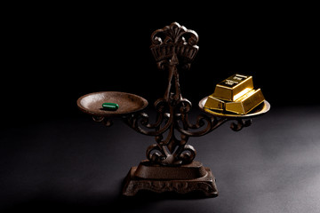 capsule and gold bars on a balanced scale concept of expensive medicine