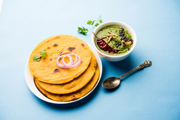 Makki di roti with sarson ka saag, popular punjabi main course recipe in winters made using corn breads mustard leaves curry. served over moody background. selective focus