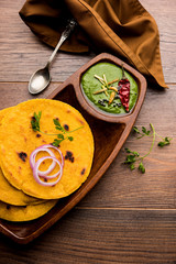 Makki di roti with sarson ka saag, popular punjabi main course recipe in winters made using corn breads mustard leaves curry. served over moody background. selective focus