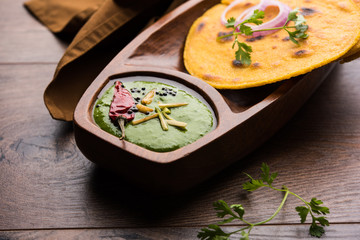 Makki di roti with sarson ka saag, popular punjabi main course recipe in winters made using corn breads mustard leaves curry. served over moody background. selective focus