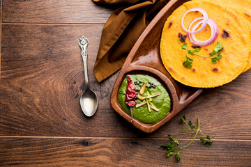 Makki di roti with sarson ka saag, popular punjabi main course recipe in winters made using corn breads mustard leaves curry. served over moody background. selective focus